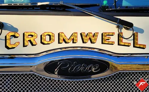Front grille close-up showing chrome script badge and mesh pattern