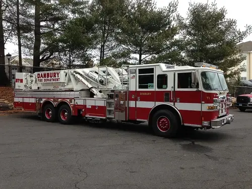Passenger-side full profile showing ladder base, side compartments, and wheel layout