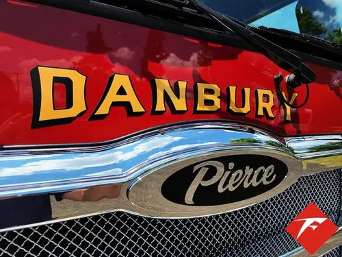Front grille close-up showing raised department script and Pierce badge