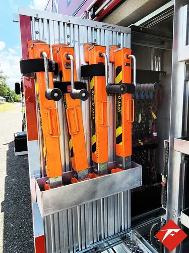 Open side compartment showing mounted extrication tools in vertical rack