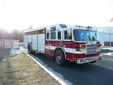 Front right exterior view of a heavy rescue truck with chrome bumper, crew cab, and long side compartments.