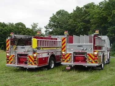 Rear view of two pumpers showing hosebed divider fins and rear chevrons
