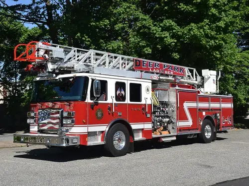 Aerial ladder truck front-left exterior view showing ladder bed and side compartments