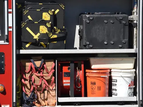 Open side compartment showing tray-mounted tools and a monitor mount panel
