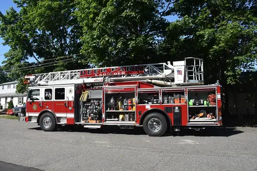 Driver-side profile with compartments open showing tools and equipment bays
