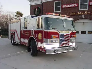 Rescue truck front-left view showing grille, bumper, and side compartments