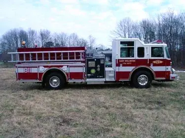 Driver-side profile view showing side hosebed rails and pump panel area
