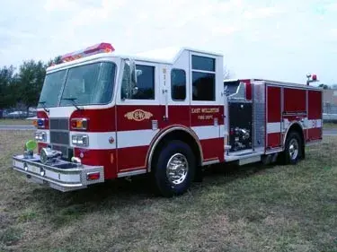 Front-right exterior view showing open side compartment and cab corner