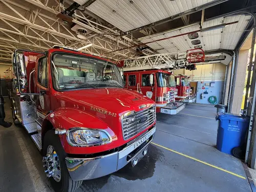 Front-right exterior view showing tanker parked inside apparatus bay
