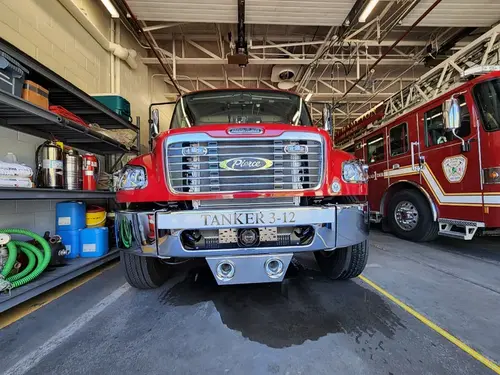 Head-on front view of tanker parked inside apparatus bay