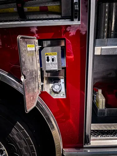 Open narrow side compartment showing mounted extinguisher and fittings