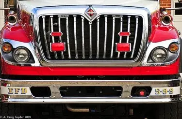 Front grille close-up showing chrome grille bars and bumper