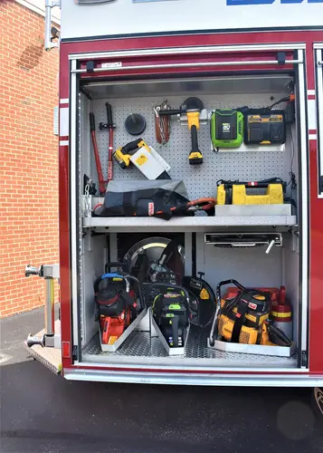 Open side compartment showing hand tools and small equipment storage