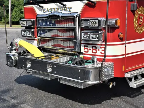 Front bumper close-up showing intake ports, warning lights, and unit number