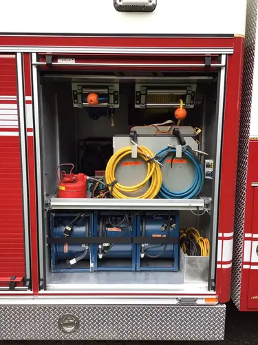 Open compartment with cable reels, cords, and portable equipment