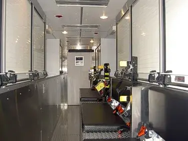 Interior rear aisle view showing seating and secured SCBA gear along wall