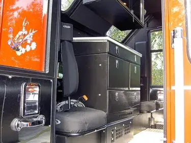 Cab interior side view showing bench seat and black drawer storage cabinet