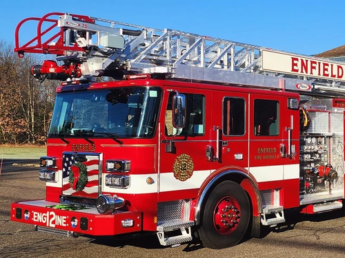 Aerial ladder truck front-left exterior view showing cab, grille, and ladder bed