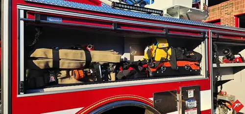 Open side compartment showing mounted long tools and shelf storage