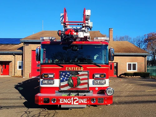 Head-on front view showing grille, bumper, and ladder tip above cab