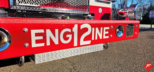 Front bumper close-up showing raised unit lettering and warning light strip