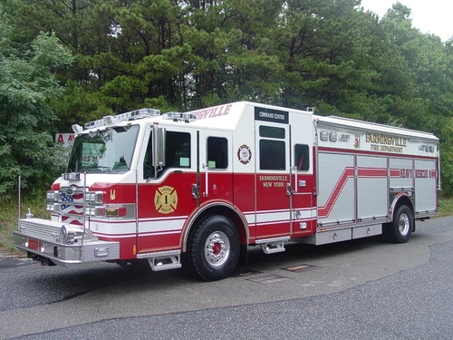 Front left exterior view of the heavy rescue with command cab, chrome bumper, and side roll-up compartments.