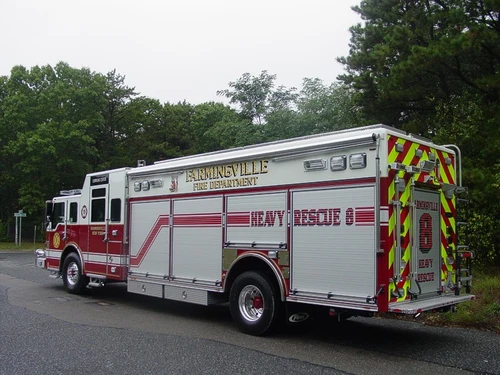 Rear right side view showing long compartment body, rear chevron striping, and wheel area.