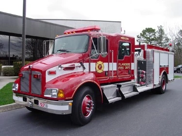 Front-left exterior view of pumper showing long hood cab and side pump panel area