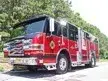 Wide front right view of the parked pumper showing bumper, cab, and full side body.
