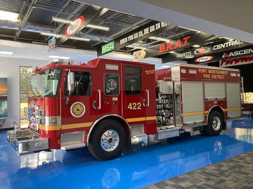 Pumper driver-side profile indoors showing side compartments and pump panel area