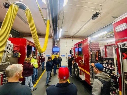 Indoor station view showing pumper lineup and overhead exhaust hoses