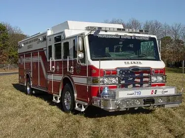 Front-left exterior view of heavy rescue truck showing chrome bumper and long body
