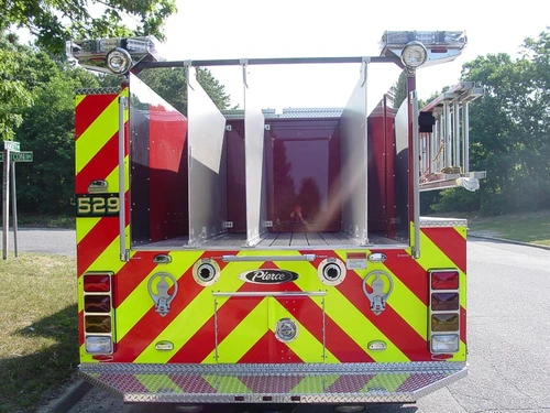 Straight rear view showing open rear hosebed bays, rear chevrons, and rear intake fittings.