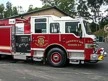 Wide front-left view of the pumper parked in the lot with full side body visible.
