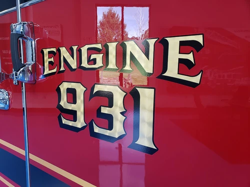 Body side close-up showing raised unit lettering on red paint
