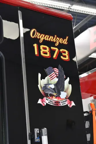 Cab door-jamb close-up showing station patch and unit number