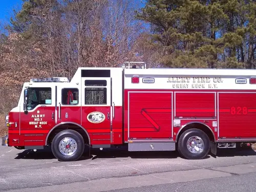 Driver-side full profile showing the enclosed cab, side roll-up compartments, and wheelbase.