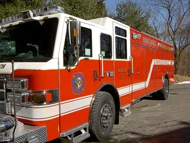 Front-left exterior view of heavy rescue truck showing cab and long side body