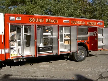 Passenger-side profile with multiple open compartments showing rescue equipment racks