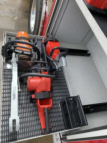 Open side compartment close-up showing cordless tools and equipment cases