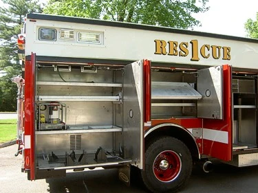 Passenger-side compartment close-up showing open storage shelves and pull-out tray