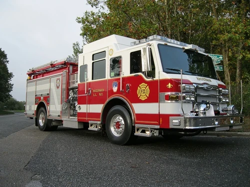 Front-right exterior view of a pumper with enclosed cab, side pump panel section, and body compartments.