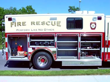 Passenger-side mid-body view with open compartments showing rescue equipment shelves