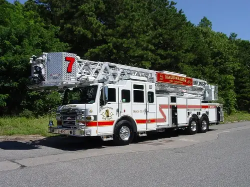 Front-left wide view showing the cab, aerial ladder bed, and full side body profile.