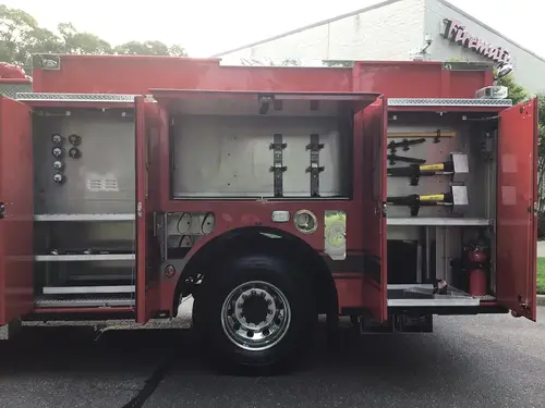 Driver-side compartments open around rear wheel with tool mounts and shelves