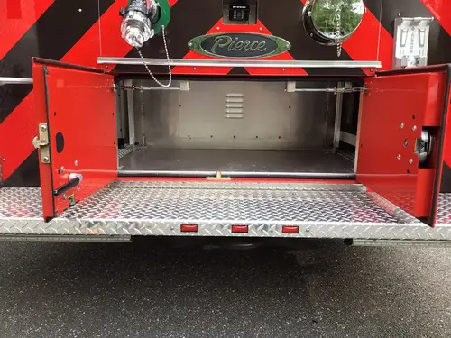 Rear step compartment open below hosebed with empty storage bay