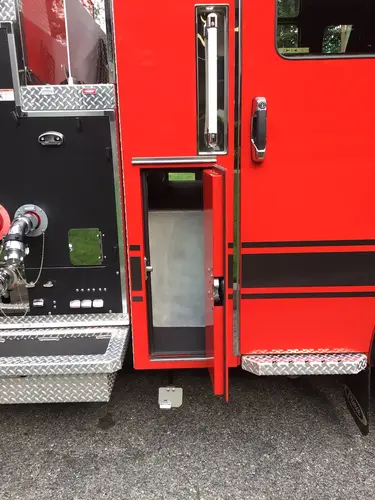 Narrow vertical compartment open behind cab with empty interior