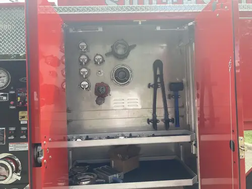Open compartment over rear wheel showing empty bottle mounts