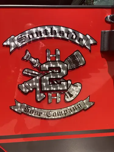 Vintage fire engine mural decal close-up on red door panel