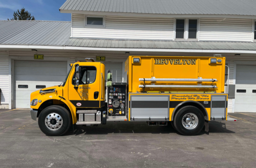 Driver-side full profile view showing pump panel and hard suction tube mount
